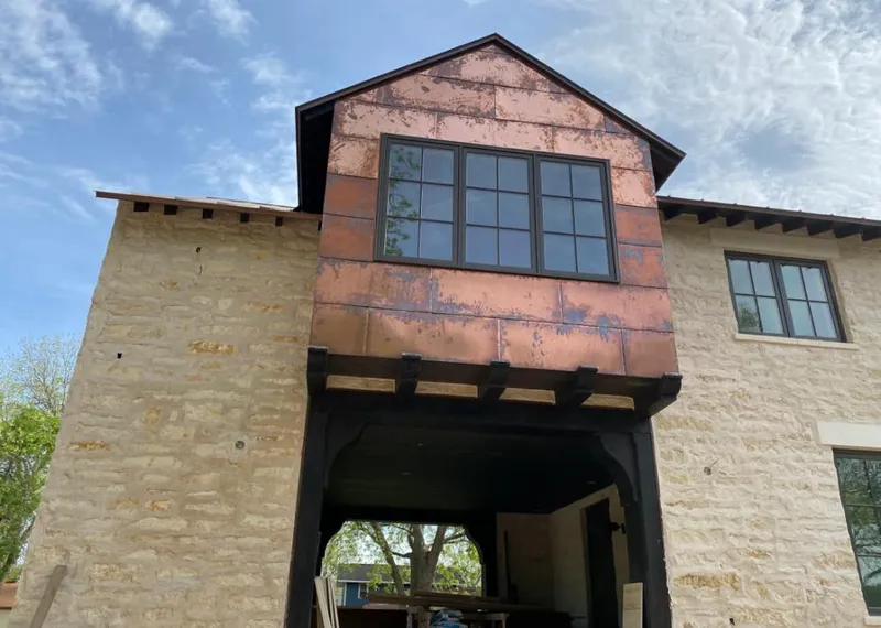 Copper metal panel facade on a stone building for Skylight Installation in Coweta
